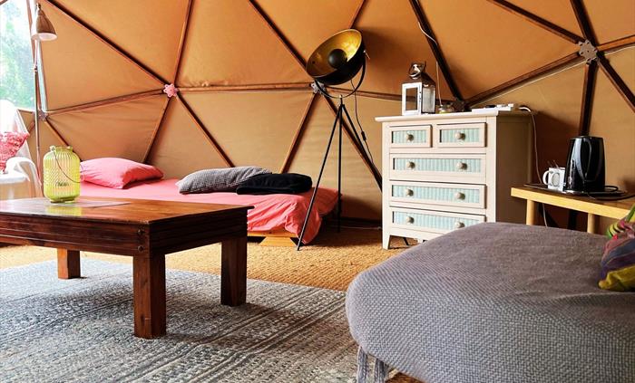 Geodome interior: single bed, futon, coffee table, tea-making facilities, chest of drawers, lamps